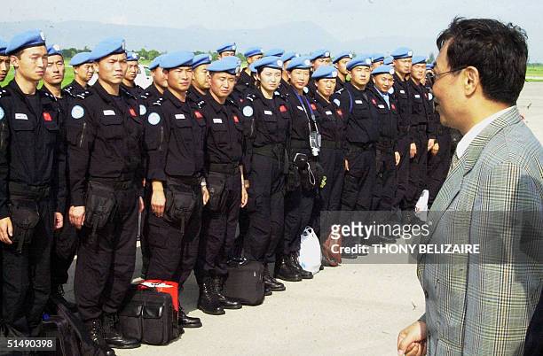 Po Quing Zhang , China's permanent representative in Haiti, speaks to Chinese police upon their arrival 17 October 2004 in Port-au-Prince from...