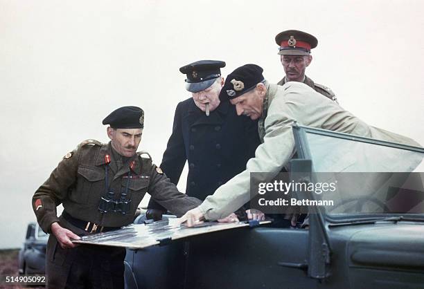 Prime Minister Winston Churchill, Field Marshal Montgomery, and Lieutenant General Sir Miles Dempsey, and G.G. Simonds examine a map in France after...