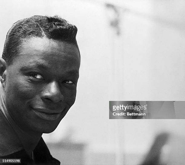 Closeups and 3/4 length of Nat King Cole on stage during performance.
