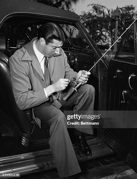 St. Petersburg, FL: Joe DiMaggio, New York Yankee outfielder, claims to be more interested in fishing than baseball as he arrives in Florida for...