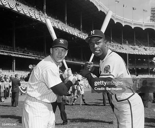 Portrait of Yankee outfielders Mickey Mantle and Hank Aaron posing in batting stance.