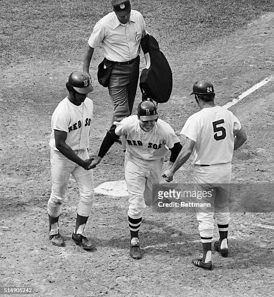 Boston, MA: Carlton Fisk of the Red Sox wears a broad smile as he is congratulated, after crossing home plate, by teammates Reggie Smith and Danny...