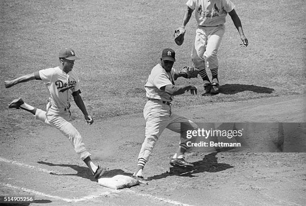 Los Angeles, CA: Dodger Maury Wills is safe on a close play at first in the first inning here August 13th. Wills dropped a bunt which was picked up...