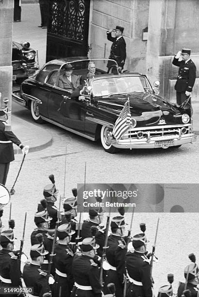Soldiers stand at attention and salute as United States President Eisenhower and Secretary of State Christian Herter arrive by automobile at the...