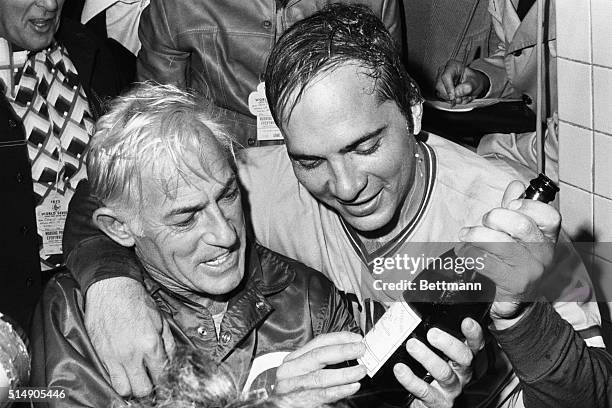 Cincinnati Reds manager Sparky Anderson and All-Star catcher Johnny Bench look over a bottle of champagne in the locker room following the club's...