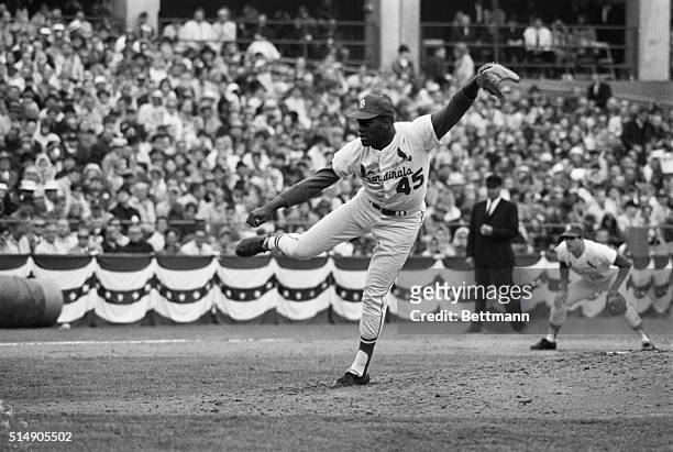 St. Louis, MO: Pitcher Bob Gibson of the Cardinals displays an unusual follow through here, as he pitches to one of the Boston players in the fourth...