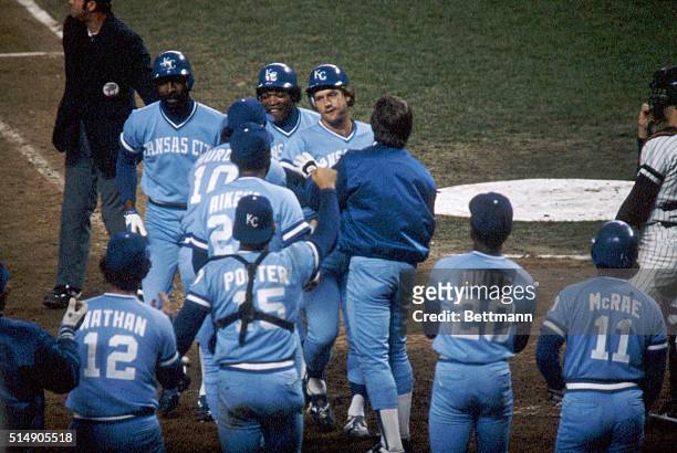 New York, NY: George Brett is embraced by teammates after hitting a towering three-run homer in the seventh inning, lifting the Kansas City Royals to...