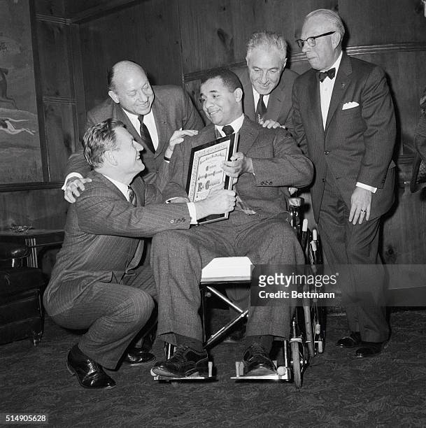 New York, NY: Former Dodger catcher Roy Campanella displays the award proclaiming him "Man of the Year," which was presented to him at a citation...