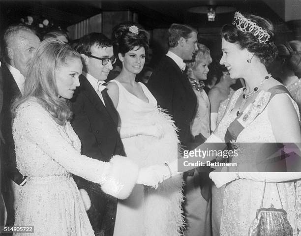 London, England: Britain's Queen Elizabeth II is shaking hands with actress Ursula Andress before the start of the Royal Film Performance 1966 film...