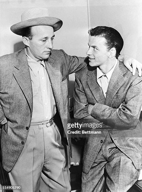 Hollywood, CA: Dean of the crooners Bing Crosby puts a friendly arm about the shoulder of Frank "The Swooner" Sinatra, as they meet for the first...