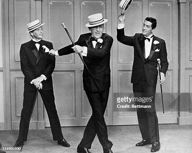Frank Sinatra and Dean Martin stand behind a singing, dancing Bing Crosby in a show number from Robin and the 7 Hoods.