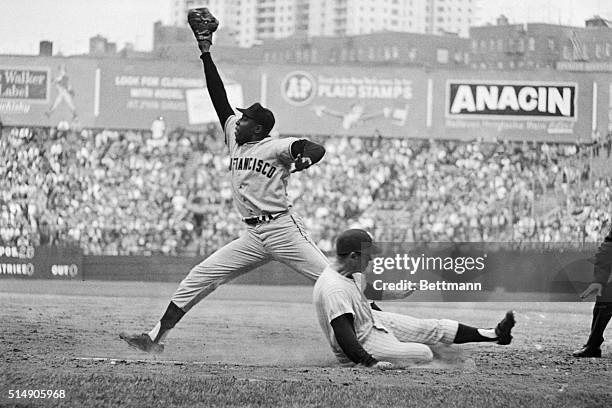 Bobby Richardson slides safely into first as Willie McCovey stretches for the late throw during game 5 of the 1962 World Series between the San...