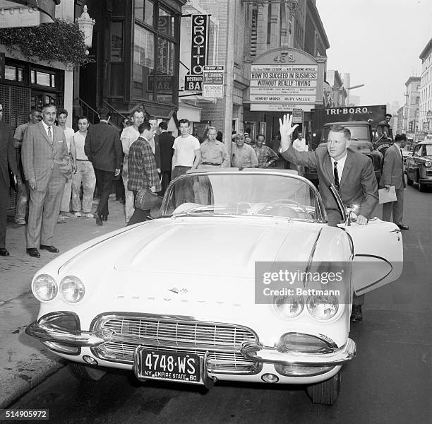 New York, NY: World champion New York Yankees' pitching star Whitey Ford waves as he gets into his white Chevrolet Corvette sports car, which was...