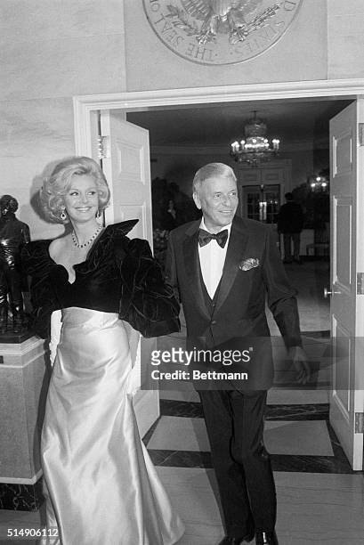 Frank Sinatra escorts his wife, Barbara, as they arrive at the White House to attend the 70th birthday celebration of President Ronald Reagan.