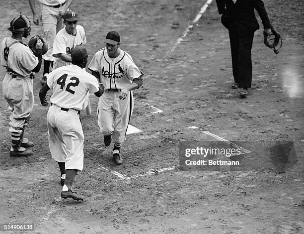 New York, NY- Outfielder Stan Musial, St. Louis Cards, crosses the plate after his first inning homerun and gets a handshake from second baseman...