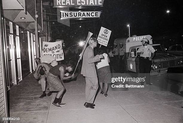 Chicago, IL- Civil rights demonstrators duck in an effort to avoid flying rocks and firecrackers hurled at them during a protest march against...