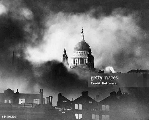 The large dome of St. Paul's Cathedral is wreathed in smoke from buildings burning after a German air raid in World War II.