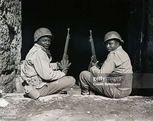 Italy: Pvt Jackson Brown of Dele, SC, and Pvt Roy Williams of Savannah, GA, sit and enjoy the sunshine at the entrance to an air raid shelter of the...