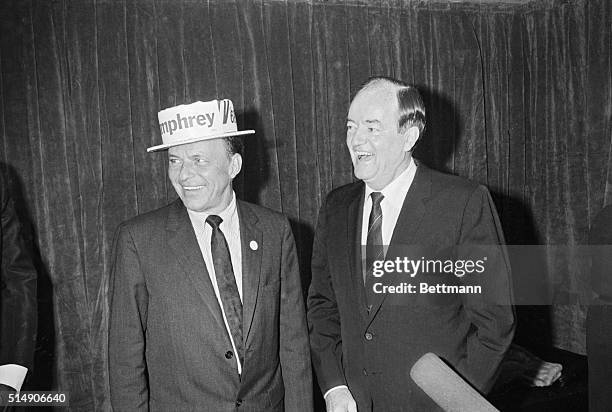 Detroit, MI: Vice President Hubert Humphrey puts a campaign hat on entertainer Frank Sinatra after a Democratic fund drive show in Cobo Hall. The...