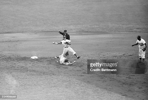 New York, NY- Cincinnati's Johnny Temple slides into second base and is forced out by Dodger shortstop Pee Wee Reese, who took the throw from Jackie...