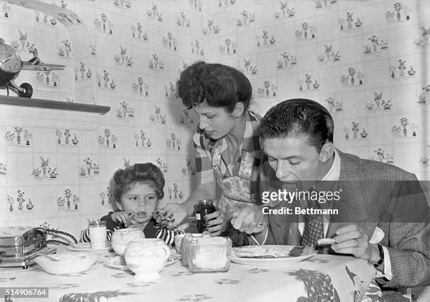 Frank Sinatra eating breakfast with his daughter Nancy while his wife Nancy brings the jam. Undated photo.
