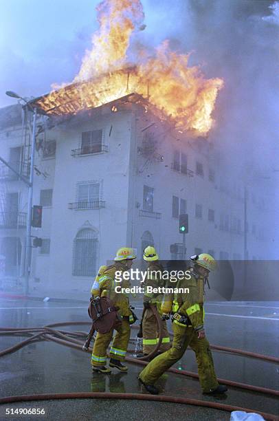 Firefigters watch an apartment building burn during the 1992 Los Angeles Riots.