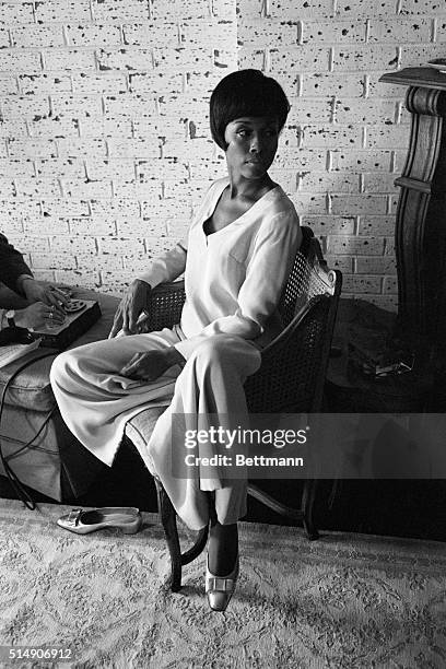 On her own- doing what she likes to do, Miss Diahann Carroll is a long, lithe, lovely creature. She is depicted seated on a chair posing full length.