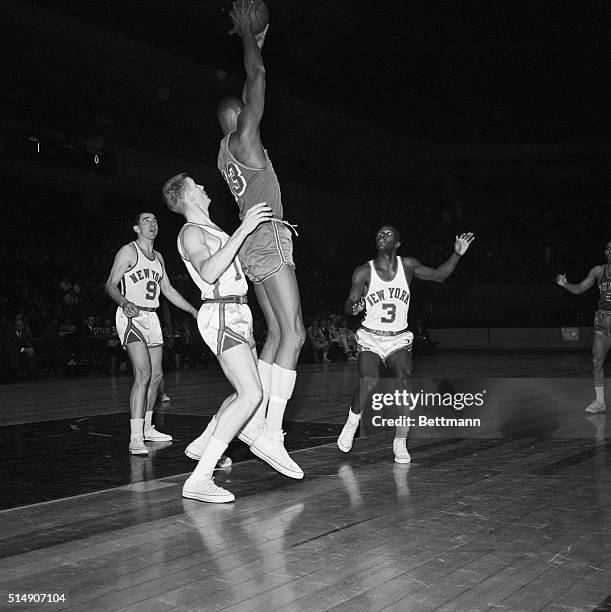 New York, NY- New York Knickerbocker players appear helpless to stop Philadelphia's seven-foot-one Wilt Chamberlain during a Knicks-Warriors game. At...