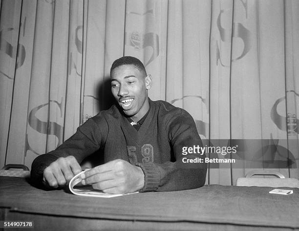 Wilt "The Stilt" Chamberlain of the University of Kansas is shown seated at a table.