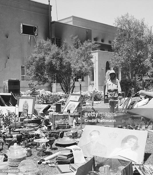 Rebel soldier stands on the lawn of the royal palace with possessions of the royal Iraqi family following a coup d'etat in which King Faisal and most...