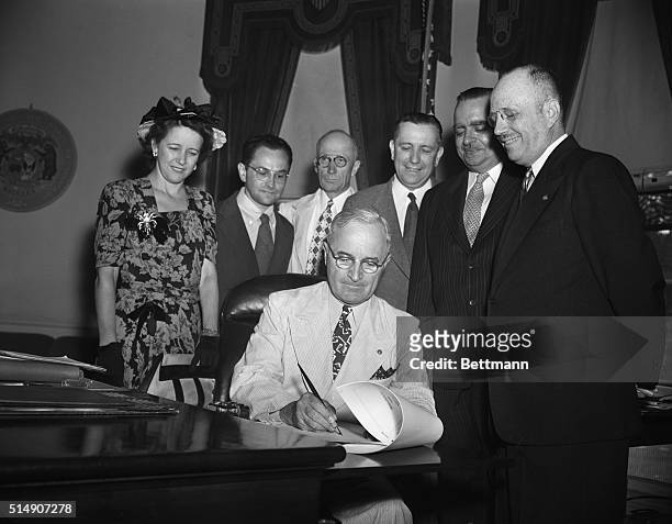 Washington, DC- President Truman is shown as he affixed his signature today to the Puerto Rican Elective Governor Bill which, effective 1948, will...