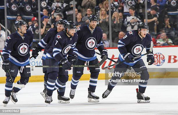 Lipon, Matt Halischuk, Ben Chiarot, Paul Postma and Andrew Copp of the Winnipeg Jets head to the bench after celebrating a third period goal against...