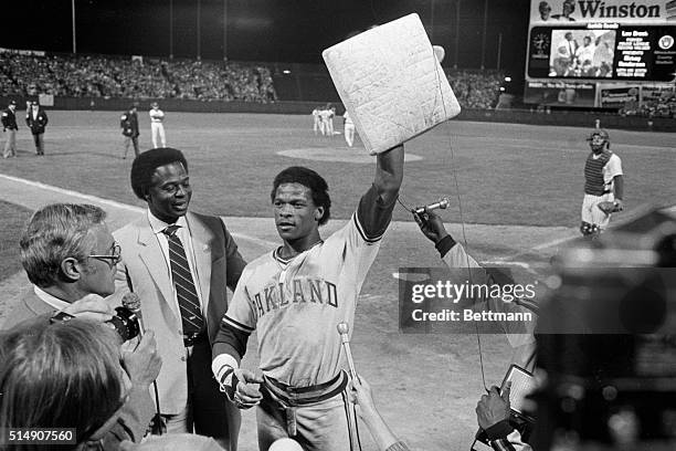 Milwaukee, WI- Oakland A's Rickey Henderson holds up second base for newsmen, after stealing his 119th base to break Lou Brock's record.