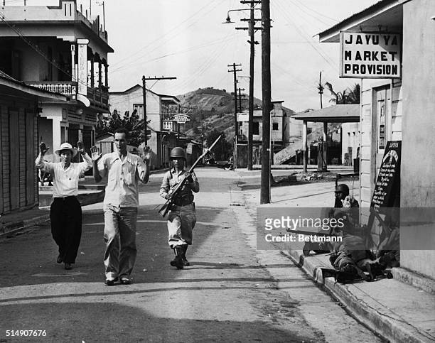 Jayuya, Puerto Rico- A National Guardsman brings in two prisoners during the clean-up of the last, nationalist, rebel strongholds in Jayuya. Other...