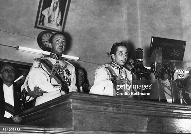 Baghdad, Iraq- While retiring regent Prince Abdul Ilah stands at left, 18-year-old King Faisal II of Iraq takes the twenty-one word oath to become...