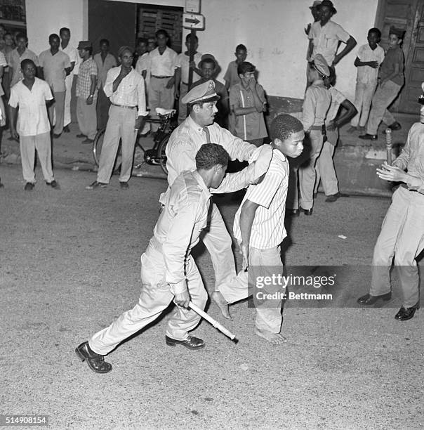 Cuidad Trujillo, Dominican Republic-Two policemen collar a barefoot youth Oct. 18 as anti-government demonstrations continued in this Caribbean...