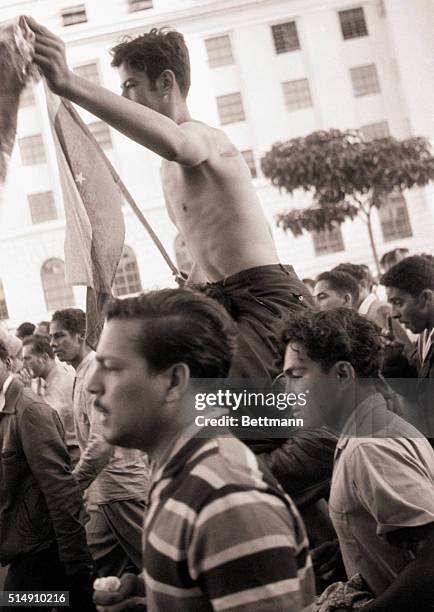 Caracas, Venezuela-The crowd celebrating the downfall of dictator Marcos Perez Jimenez carries a soldier, who was reportedly totured by the...