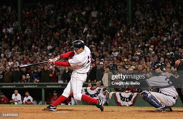 Bill Mueller of the Boston Red Sox hits a game-tying RBI single in the ninth inning against the New York Yankees during game four of the American...