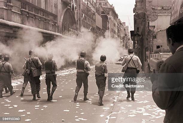 Buenos Aires, Argentina-Police fire tear gas ahead of them, as they advance down the street behind retreating demonstrators. About 200 persons...