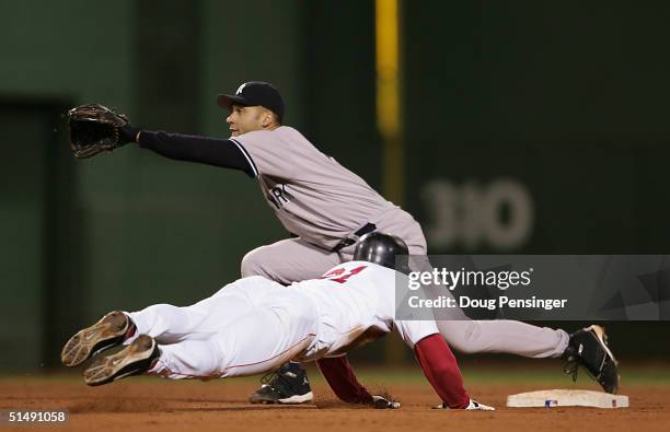 Dave Roberts of the Boston Red Sox steals second base while shortstop Derek Jeter of the New York Yankees waits for the throw in the ninth inning...