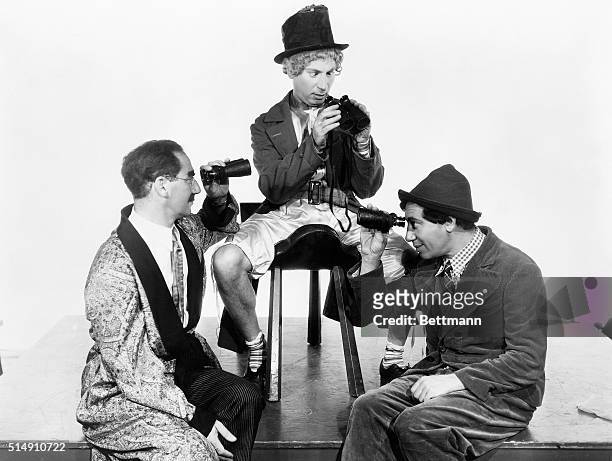 The Marx Brothers Groucho, Harpo and Chico, with binoculars.