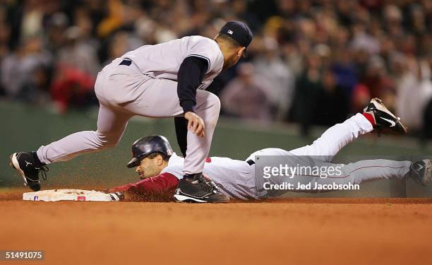 Dave Roberts of the Boston Red Sox steals second base while shortstop Derek Jeter of the New York Yankees applies the tag in the ninth inning during...