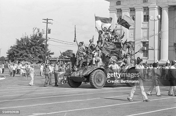 Managua, Nicaragua-Victorious Sandinista rebel forces completely cover a small mini-tank as they ride through the downtown streets singing and...