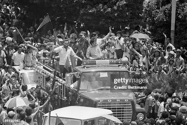 Managua, Nicaragua-Members of the 5-man junta of the Sandinista provisional government wave from the top of a fire truck as they enter the main...