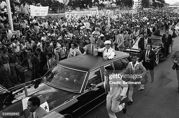 Panama City, Panama-President Jimmy Carter and Panama's General Omar Torrijos wave to Panamanians gathered along the streets as the two leaders drive...