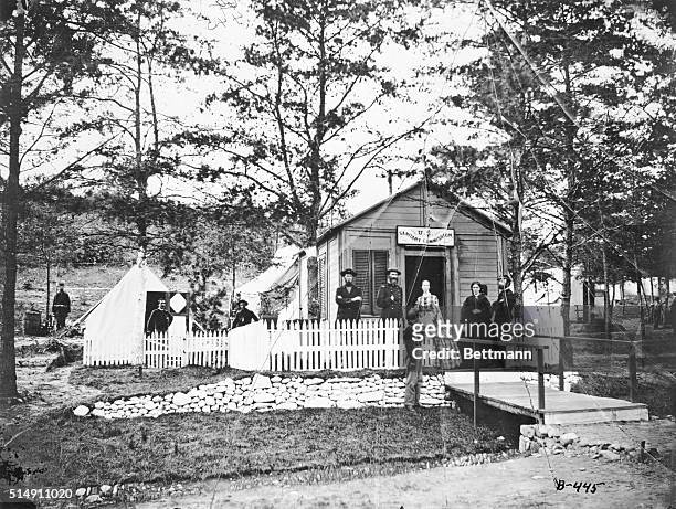 Nurses, physicians, and soldiers stand outside the field hospital of the U.S. Sanitary Commission during the United States Civil War.
