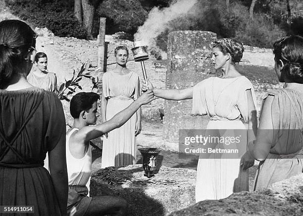 Olympia, Greece- The First Priestess of the Temple hands over the Sacred Flame to the first runner after pronouncing the Olympic Oath at the foot of...