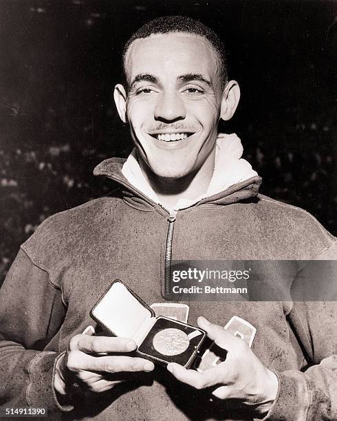 London, England- Mal Whitfield of the US displays his Gold Medal after setting a new Olympic record of 1 minute 49.2 seconds in the Men's 80-meter...