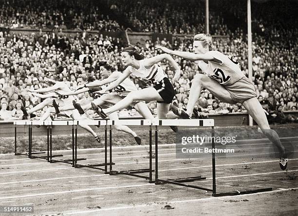 London, England- DUTCH HOUSEWIFE SETTING NEW RECORD AT OLYMPICS. Mrs. Fanny Blankers-Koen is pictured going over the hurdles during the 80 meters...
