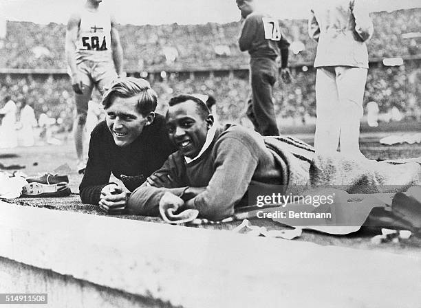 Competitors Luz Long and Jesse Owens seem very amicable watching contestants in the broad jump. Owens, representing the US, took the gold medal,...